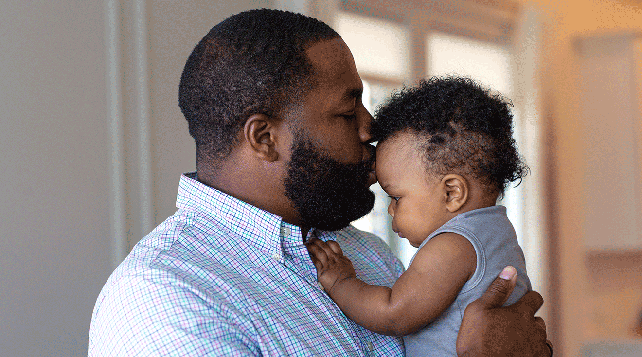 dad kissing baby at home