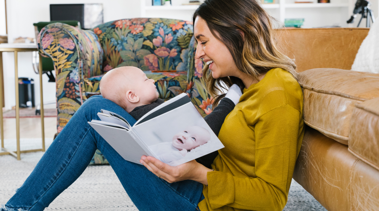 mom holding baby on her lap while looking at a photo book