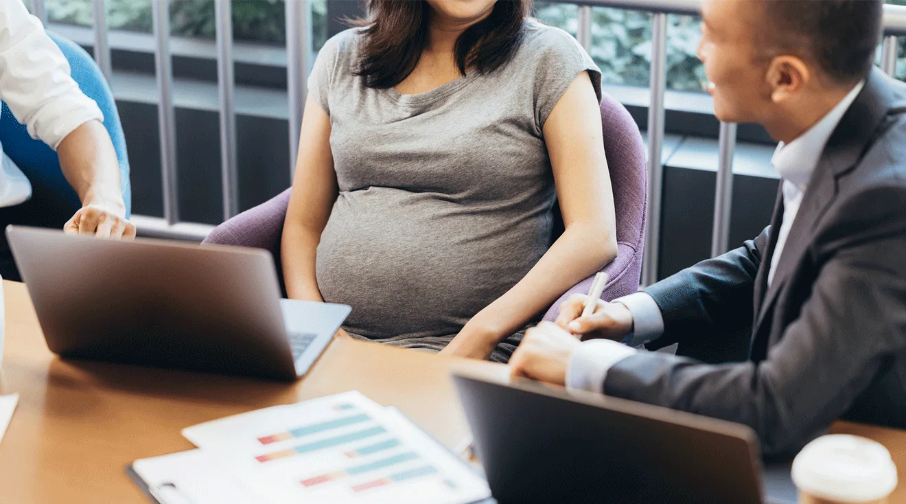 pregnant woman working in office with colleagues