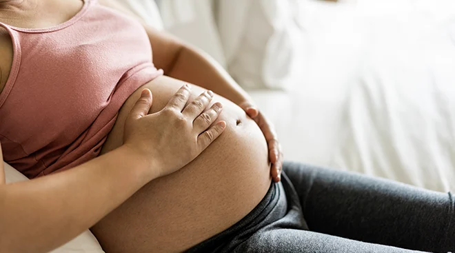 close up of pregnant woman's belly in bed