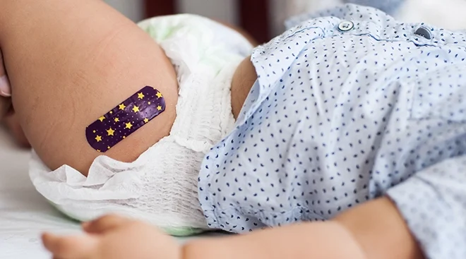 close up of band aid on baby's leg after vaccination from doctor