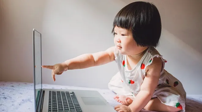 baby pointing at laptop screen
