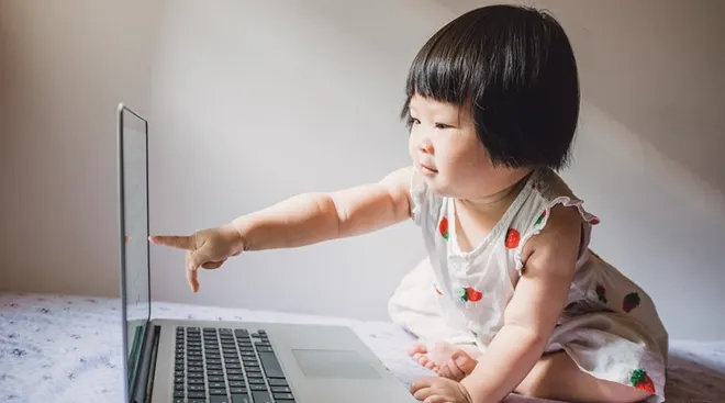 baby pointing at laptop screen