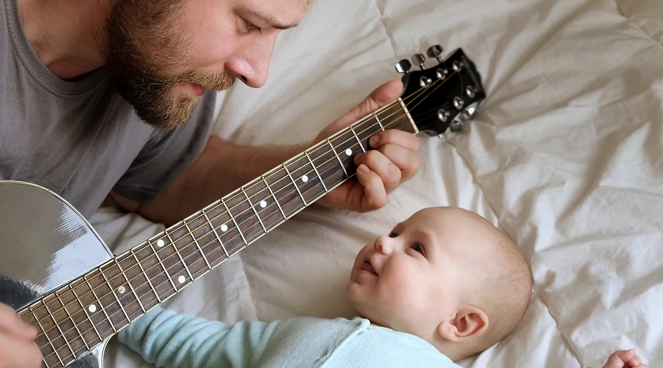dad playing guitar for baby