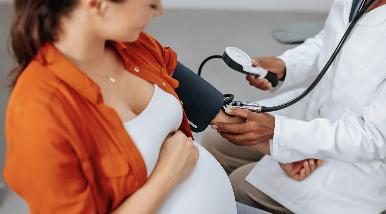 doctor taking pregnant woman's blood pressure