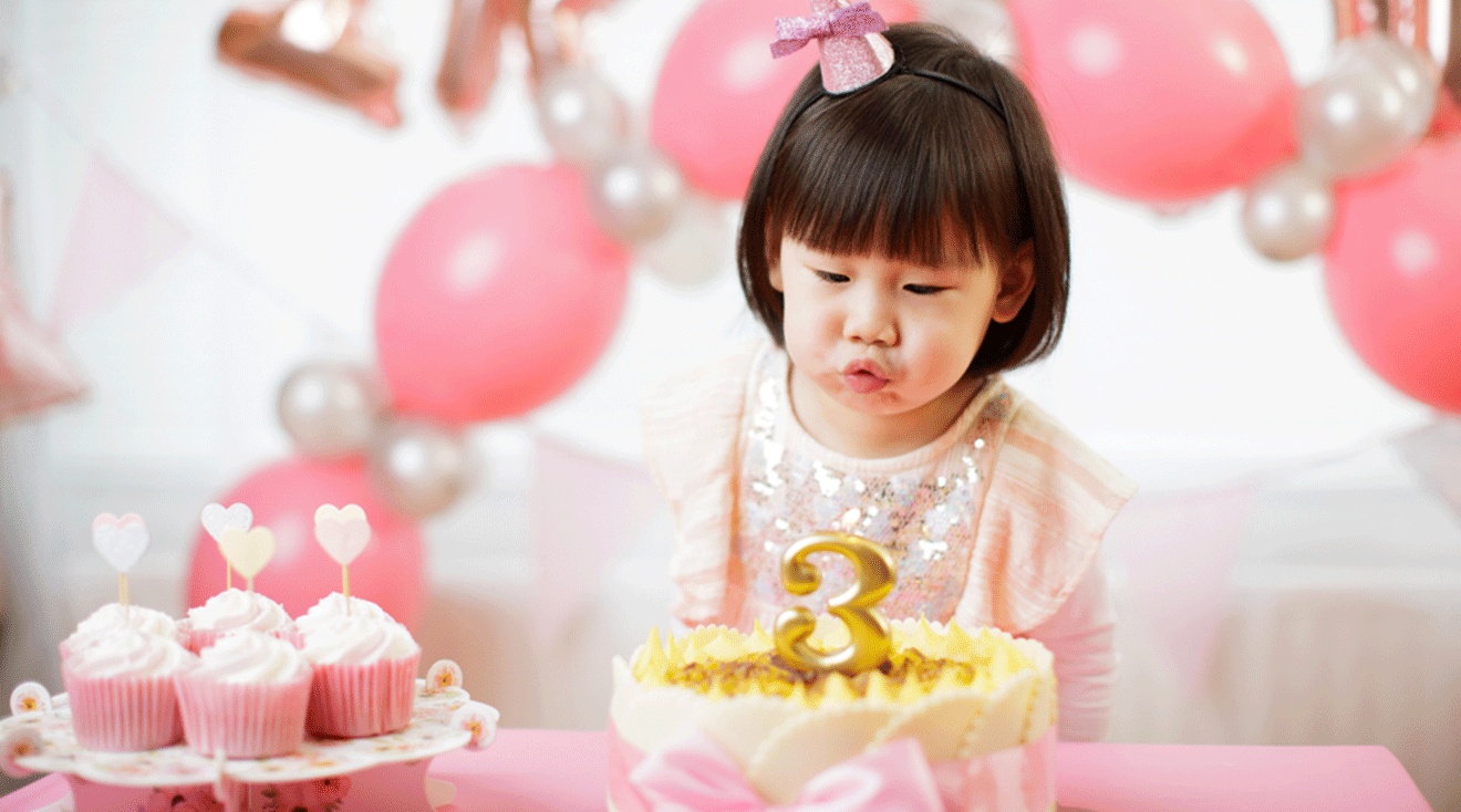 little girl turning 3 years old at her pink birthday party