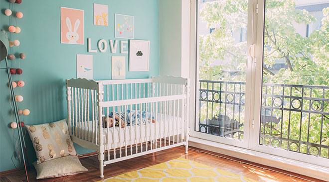 baby nursery decorated with art and baby sleeping in her crib