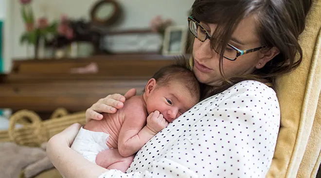 new mom consoling her newborn baby at home
