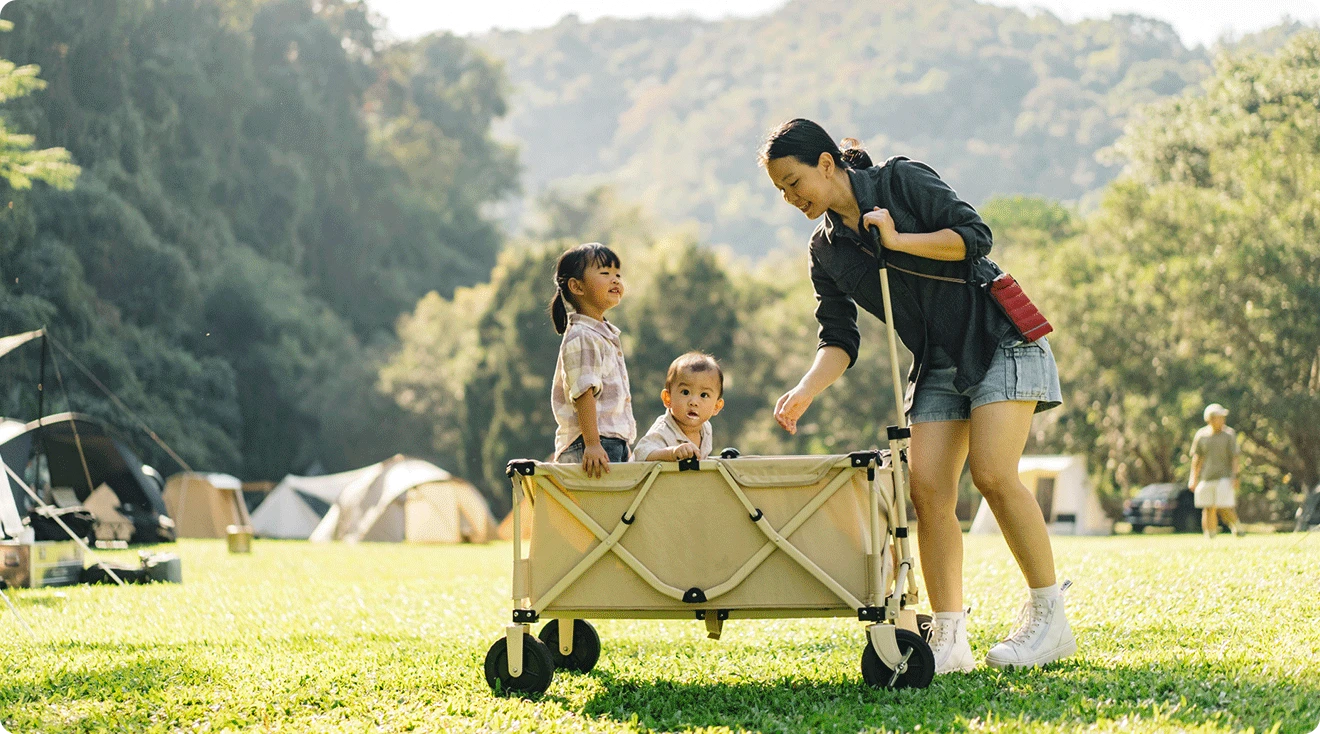 mom and two children with wagon stroller in the park