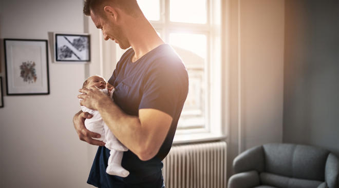 dad holding his baby at home