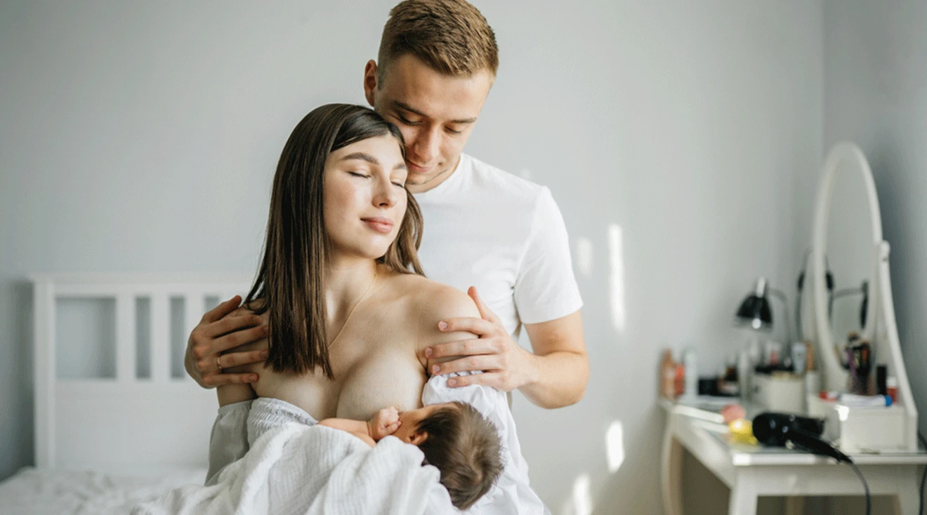 mom breastfeeding with husband at home