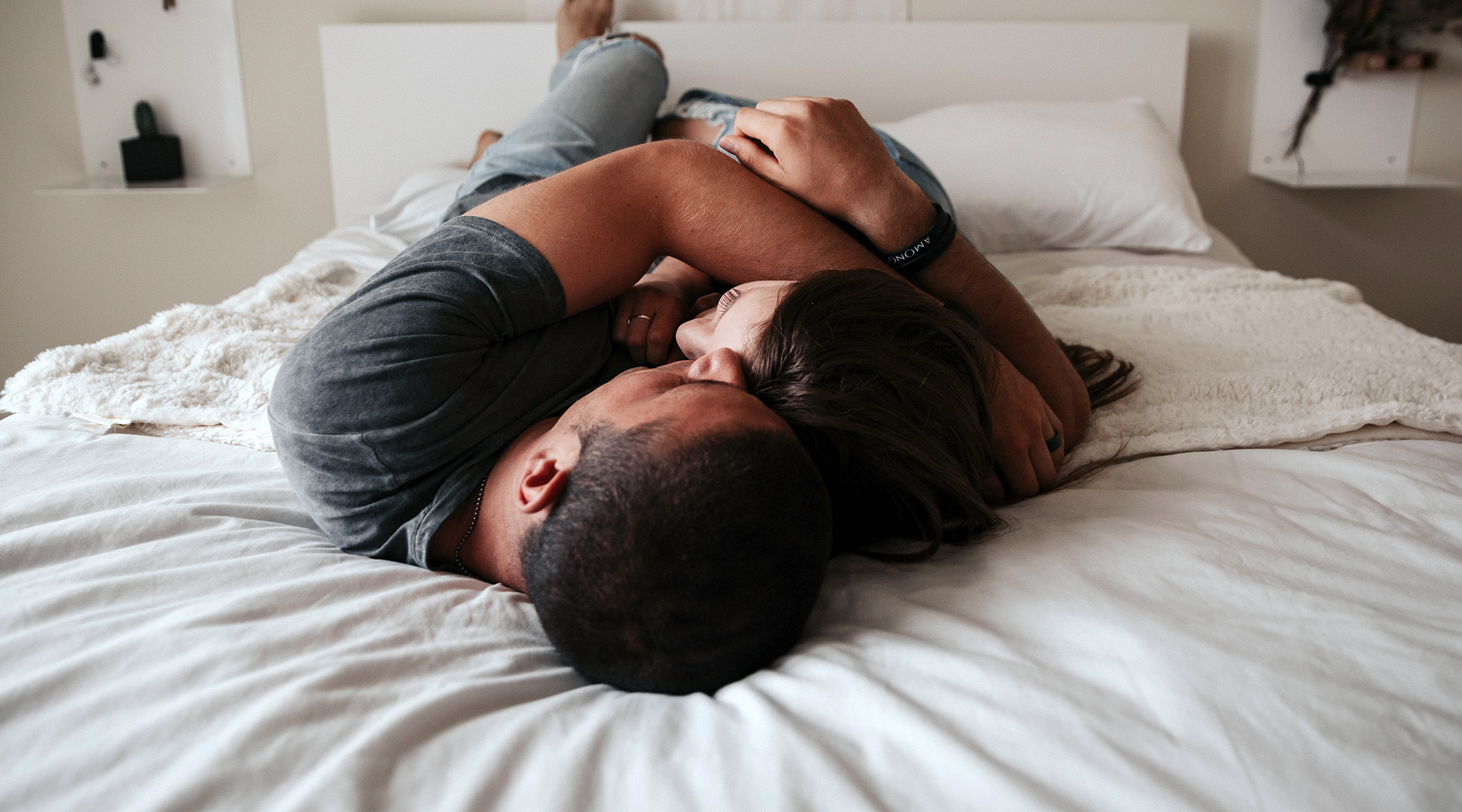 sad couple embraces on bed