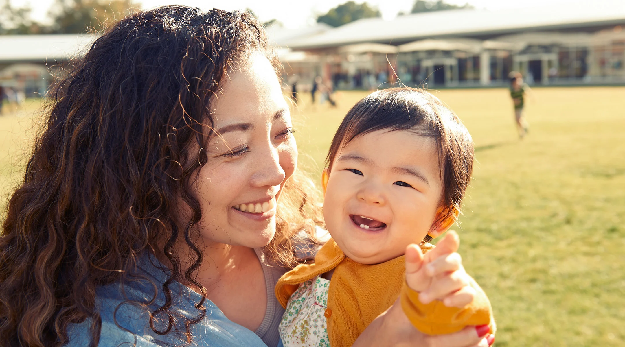 mom holding smiling baby with teeth