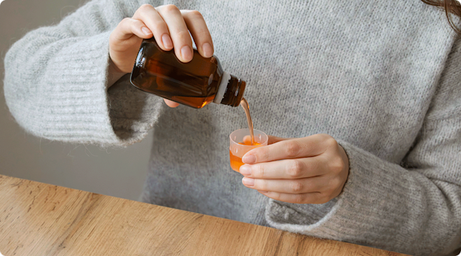 woman taking cough syrup medication