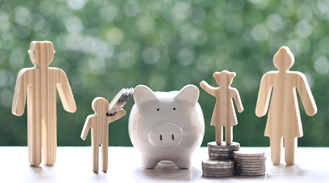 piggy bank and wooden family figures symbolizing family finances