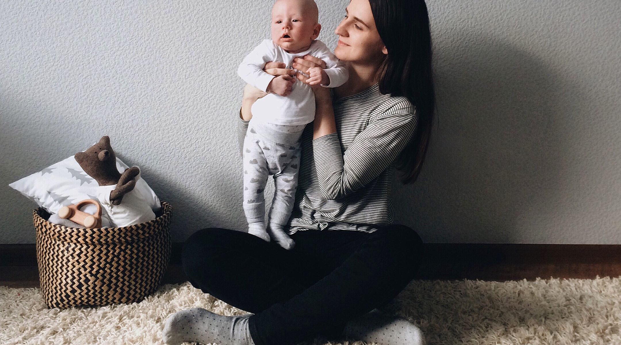 smiling mom holding up baby