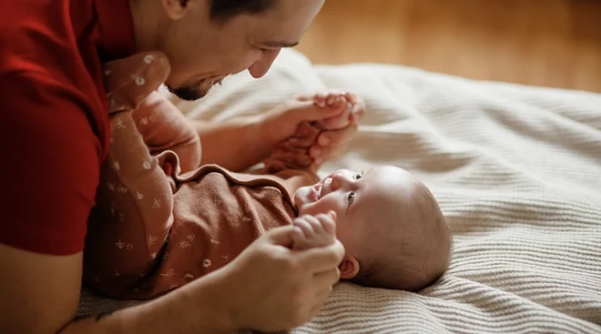 father talking to baby, smiling