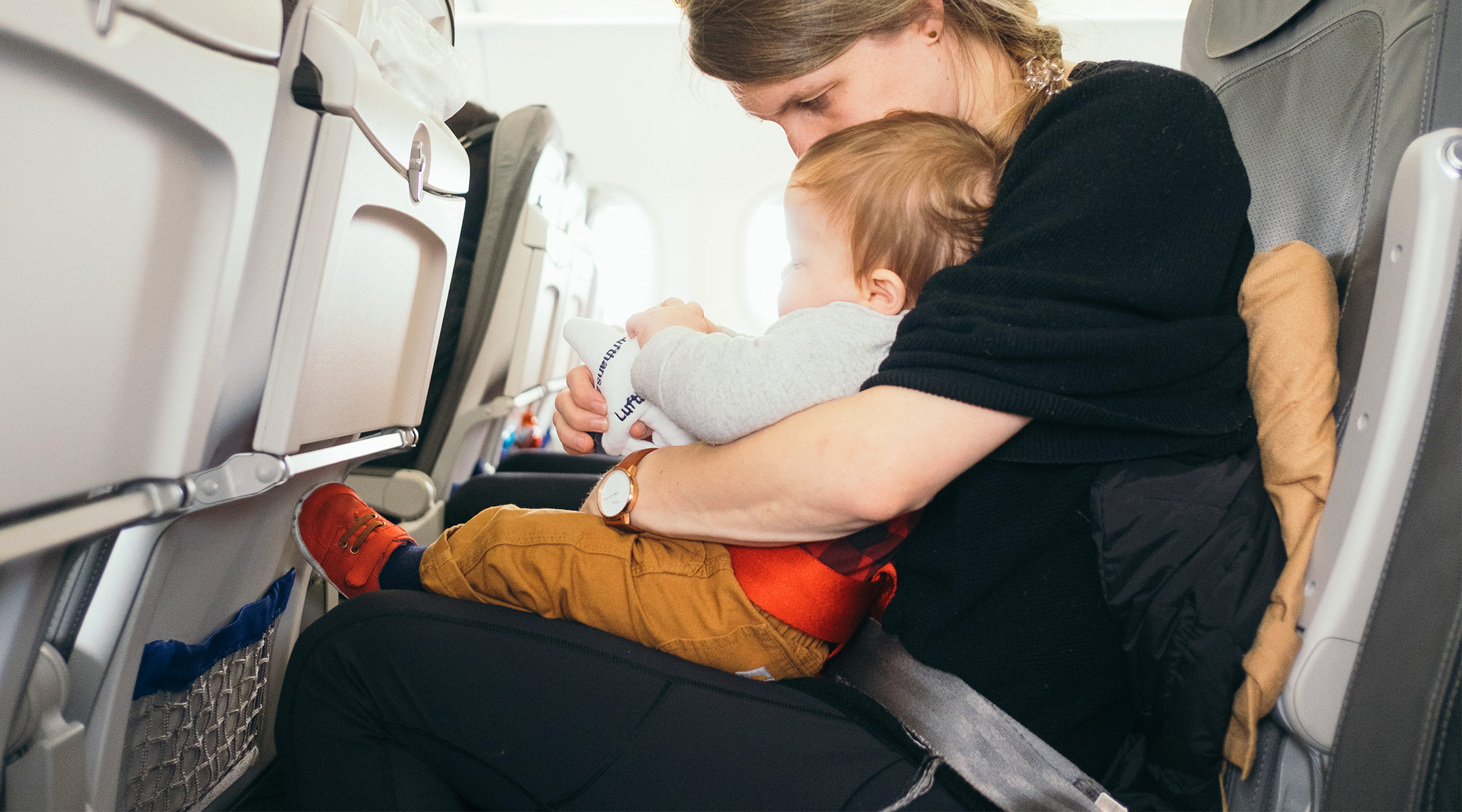 mom on airplane sitting with her baby