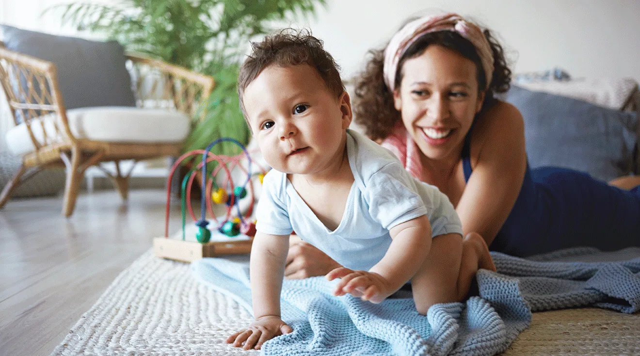 mother and baby crawling on floor at home