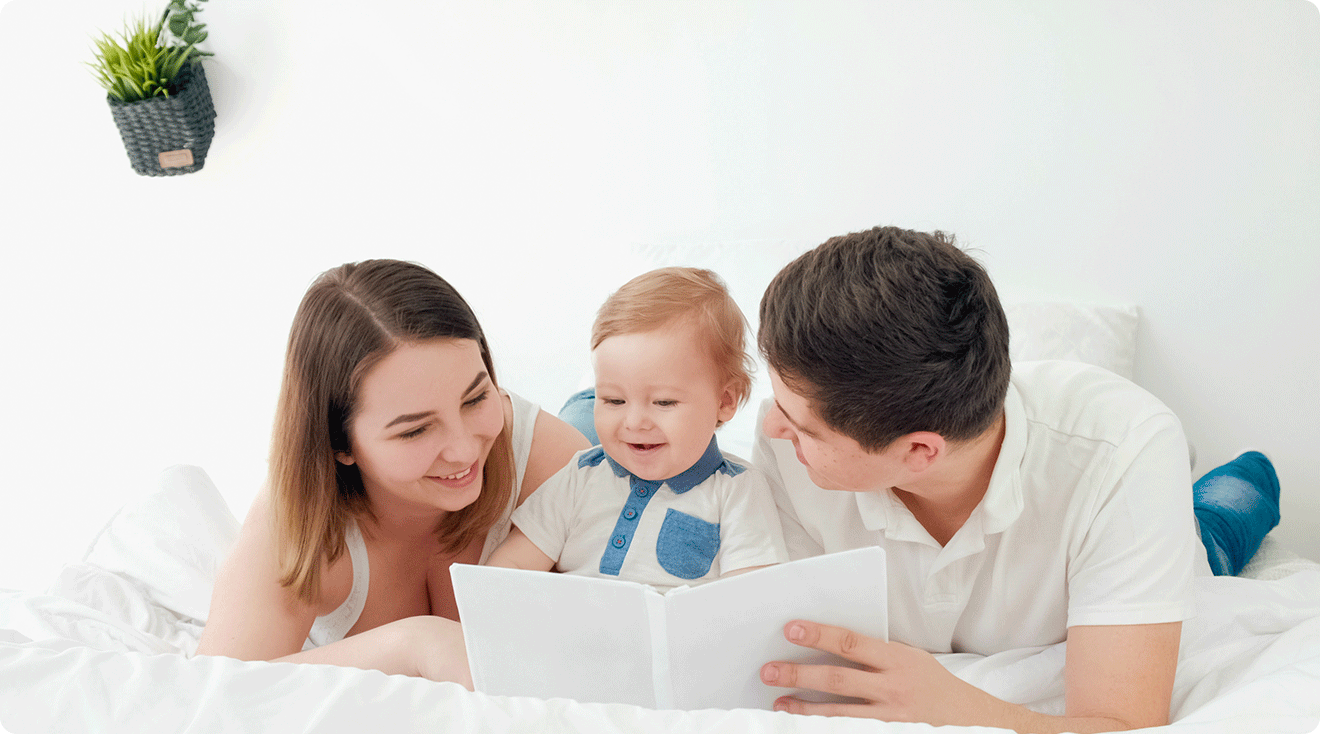 parents reading a book with baby