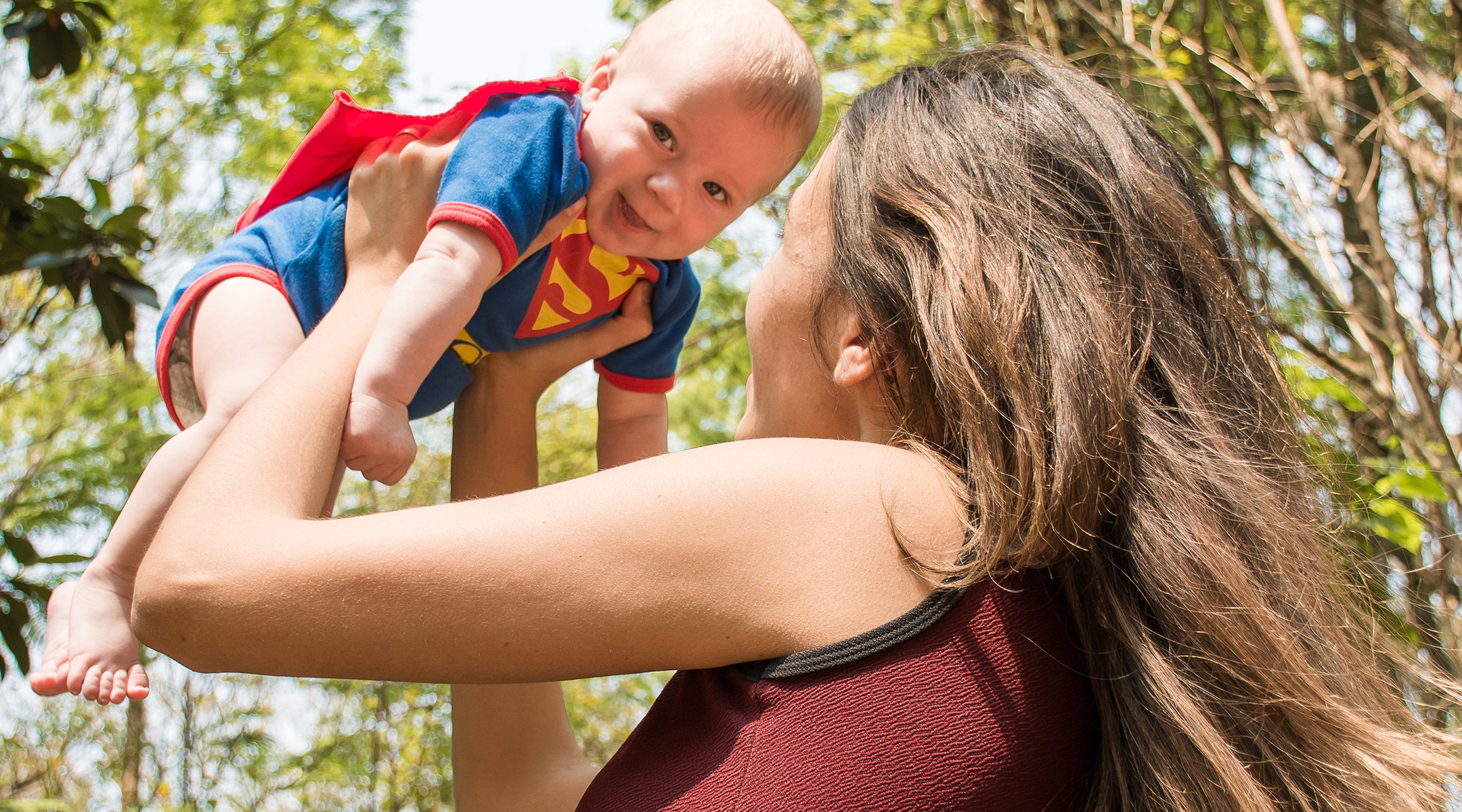 mom holding baby superman costume 