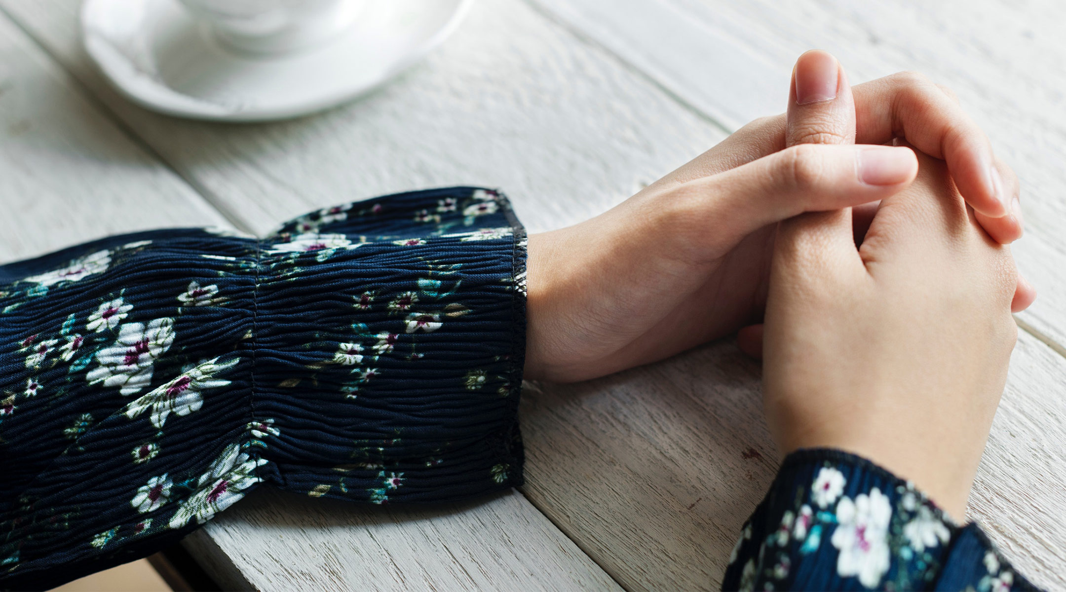 hands folded on table in a serious way