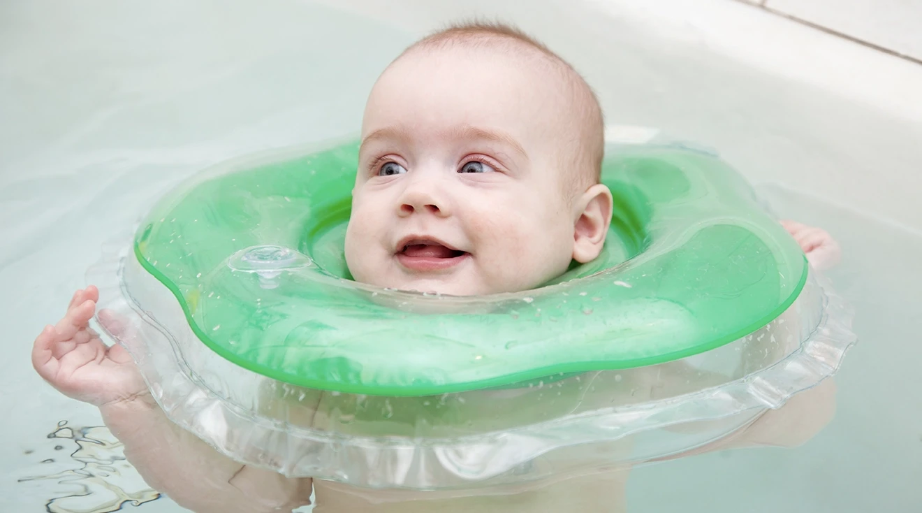 baby with neck float in bathtub