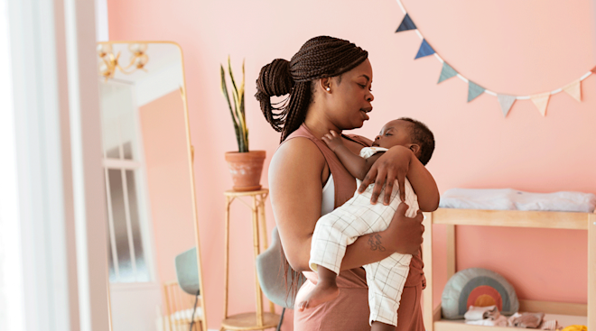 mom singing to baby in nursery