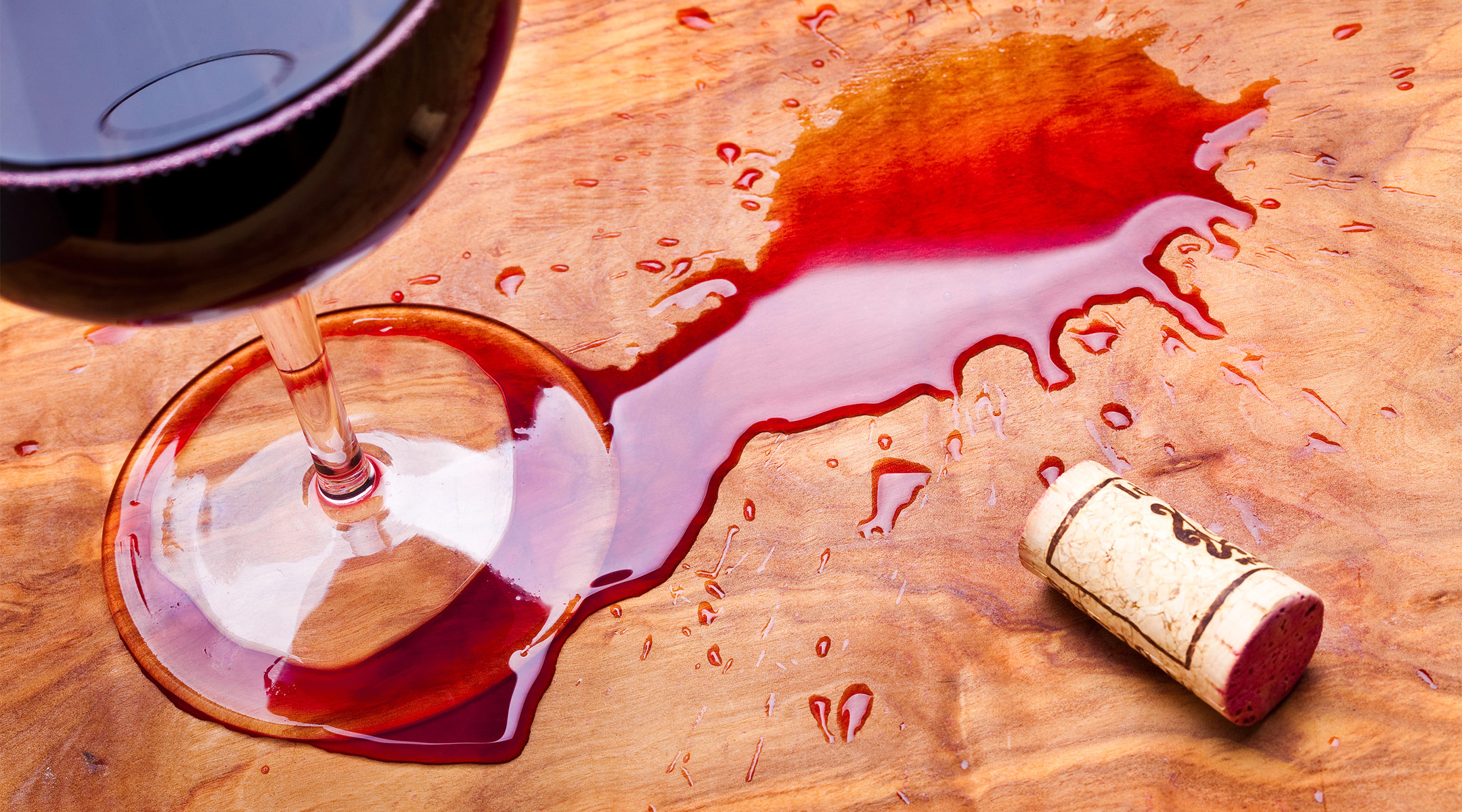 red wine glass spills over onto floor