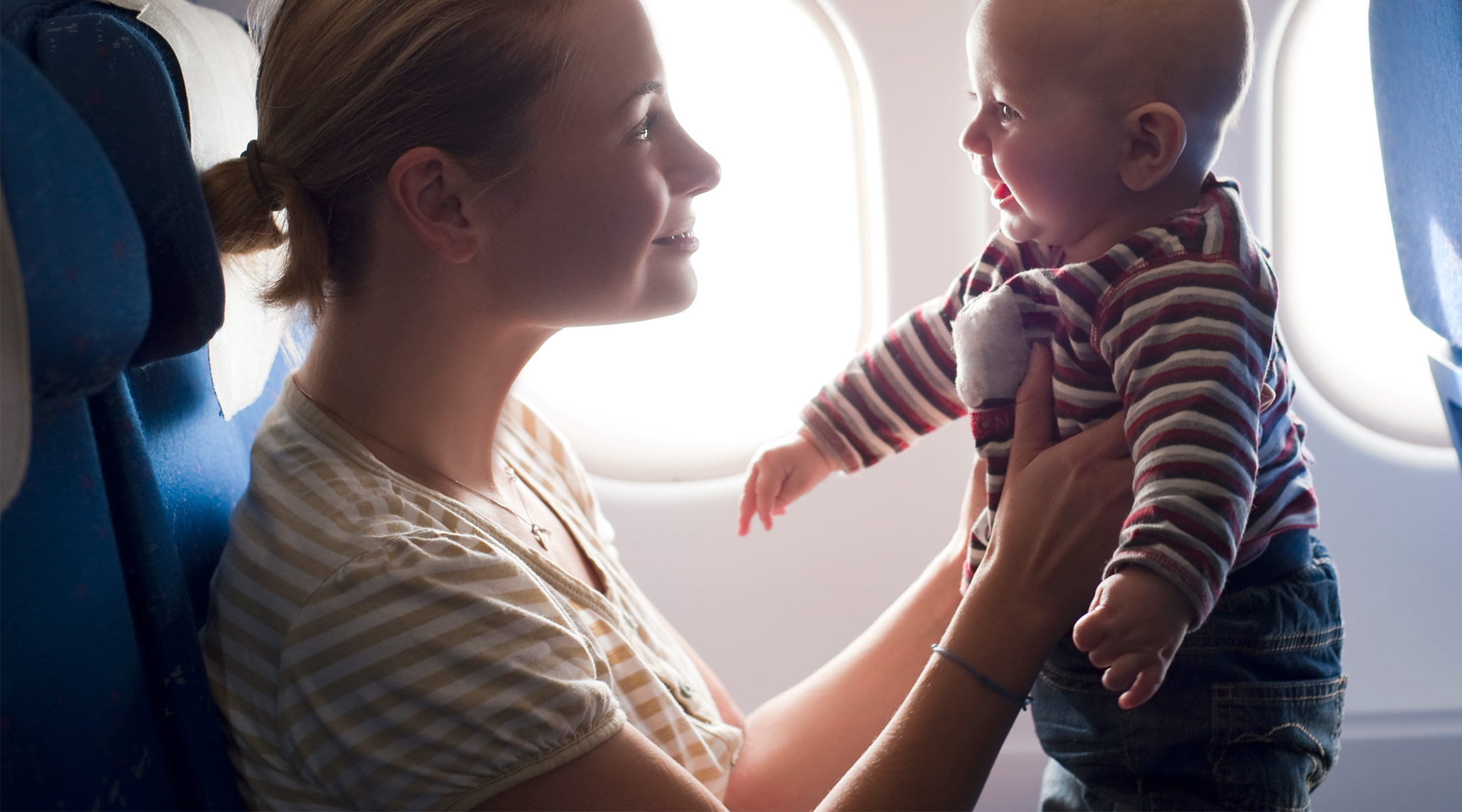 mom holds her baby on an airplane