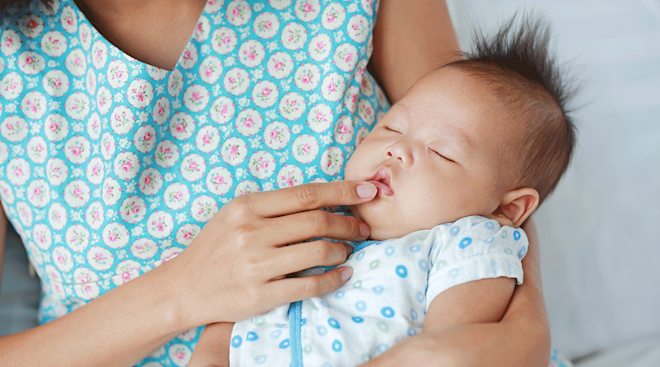 mother touching baby's lips