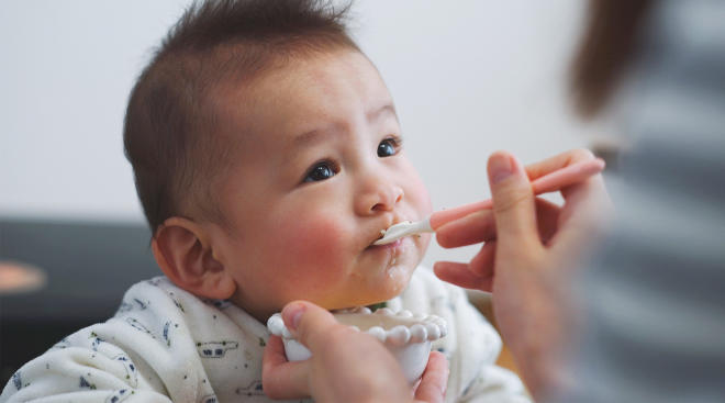 parent helps baby start solid foods