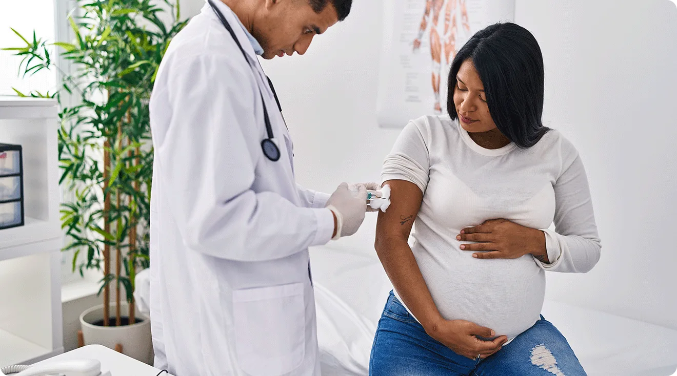 pregnant woman getting a vaccine in doctor's office