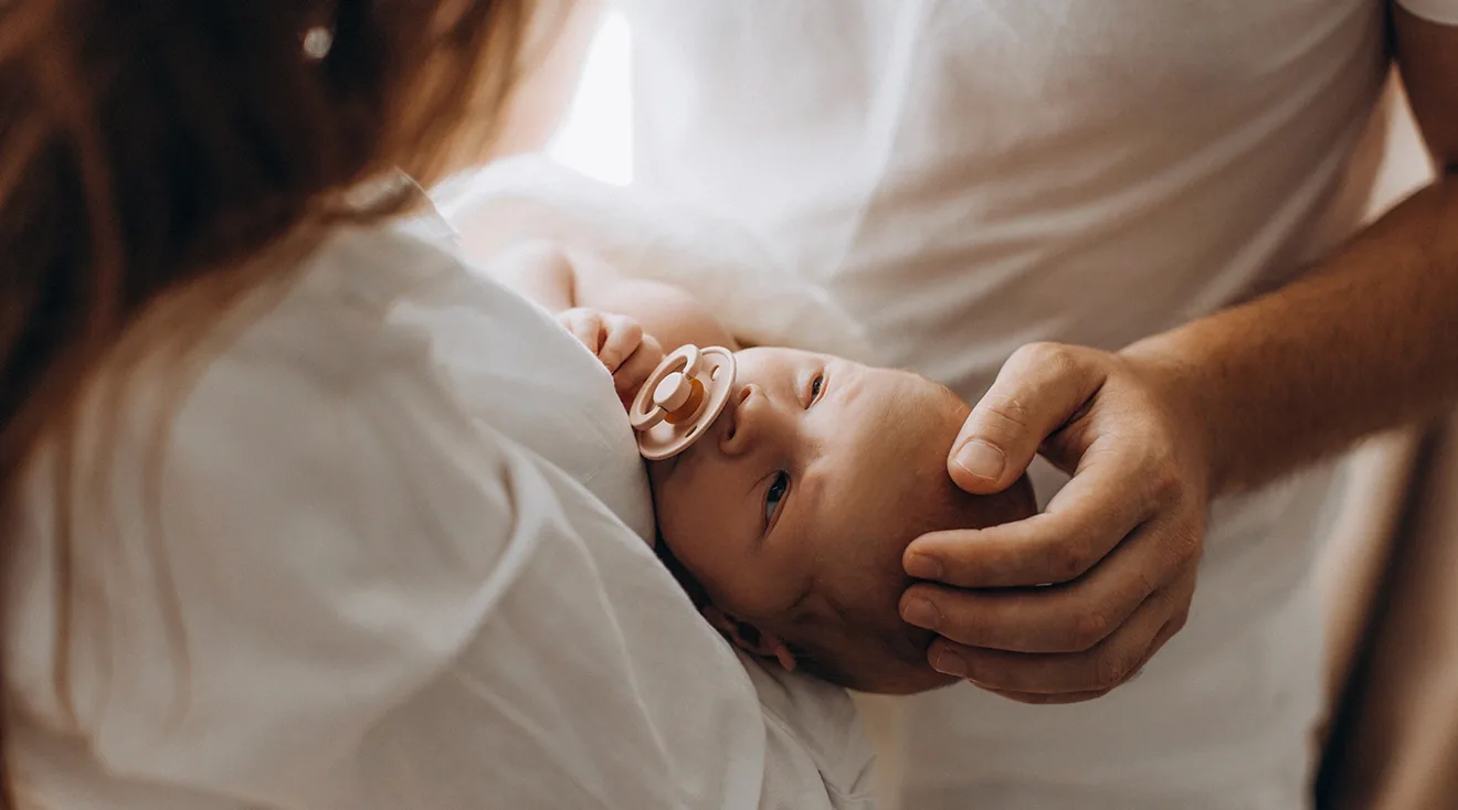 mother and father holding newborn baby