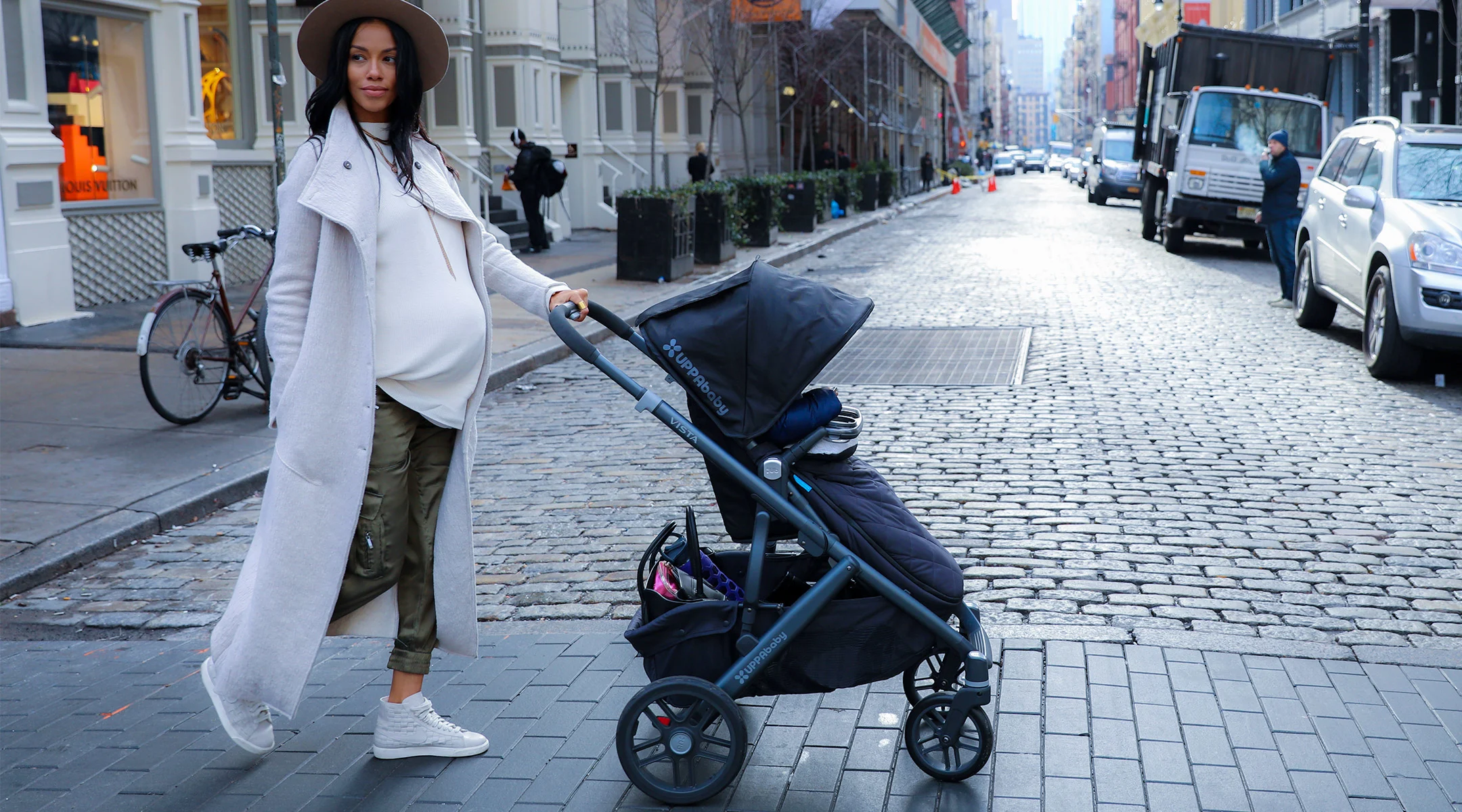 pregnant woman in urban environment crossing the street with stroller