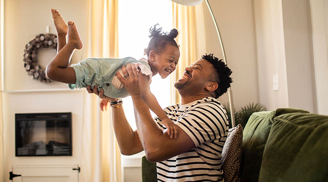 father playing with his daughter at home