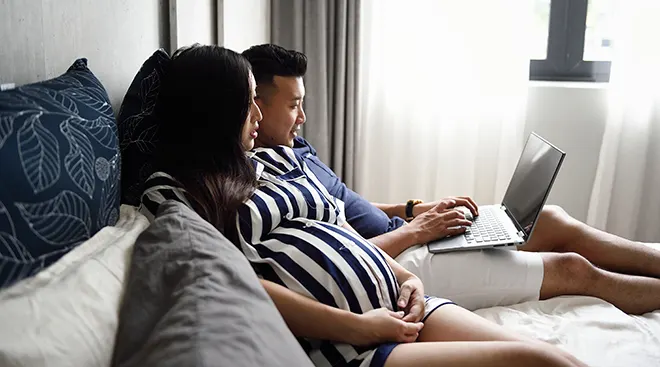 pregnant woman and man looking at computer