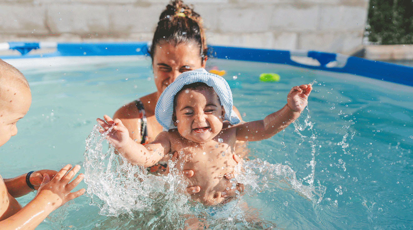 mom and baby playing in the pool on a summer day