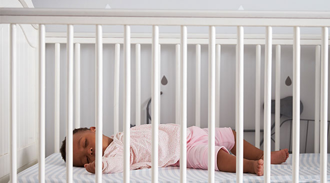 Baby sleeping in dockatot in crib sale