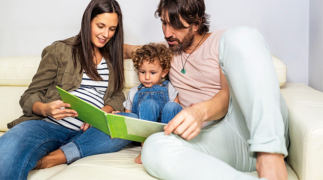 parents reading a book to their toddler