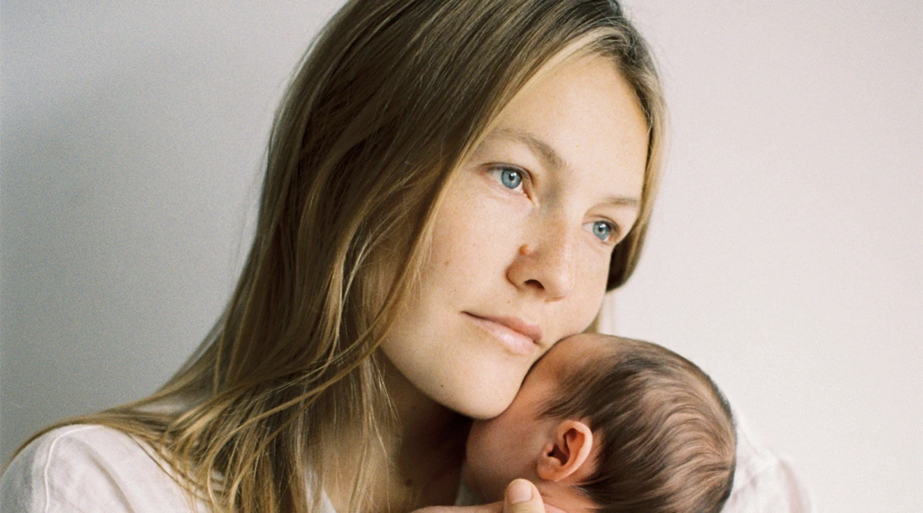 mother in deep thought while holding baby