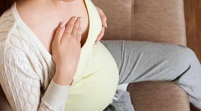 pregnant woman feeling her breast