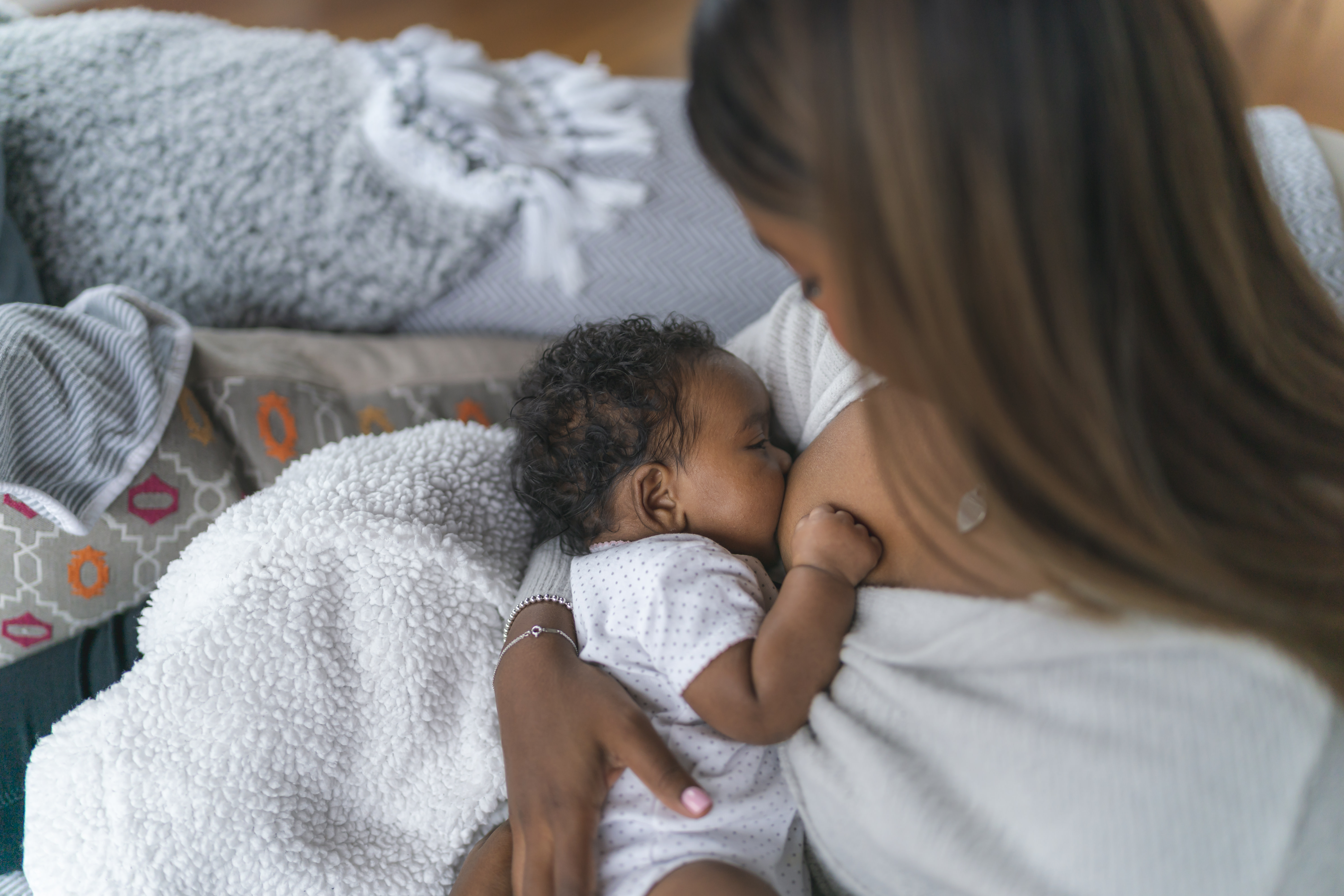 new mom breastfeeding new baby at home