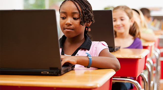 black young student in classroom on her laptop