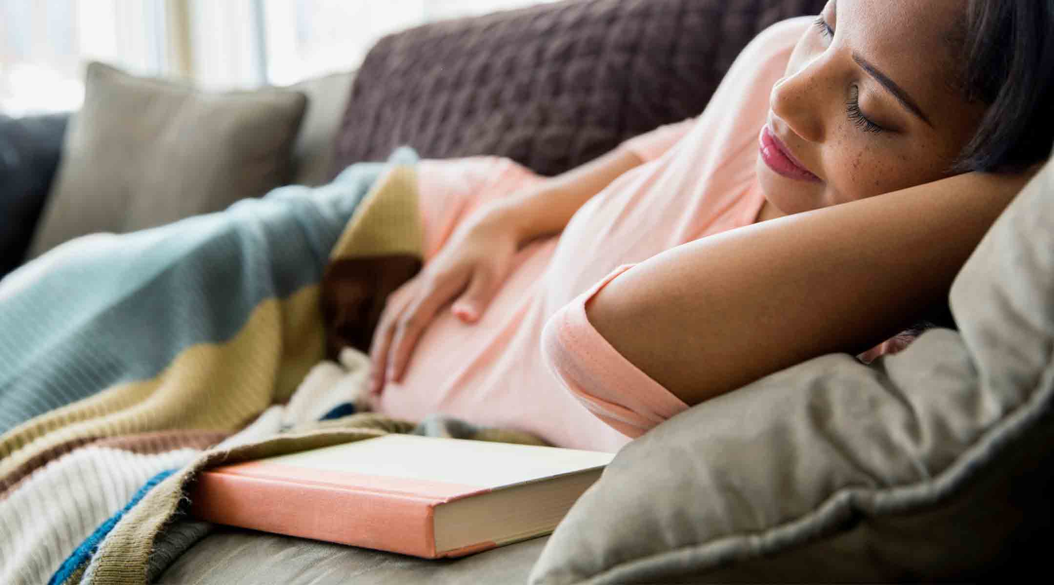 pregnant woman taking a nap on couch at home