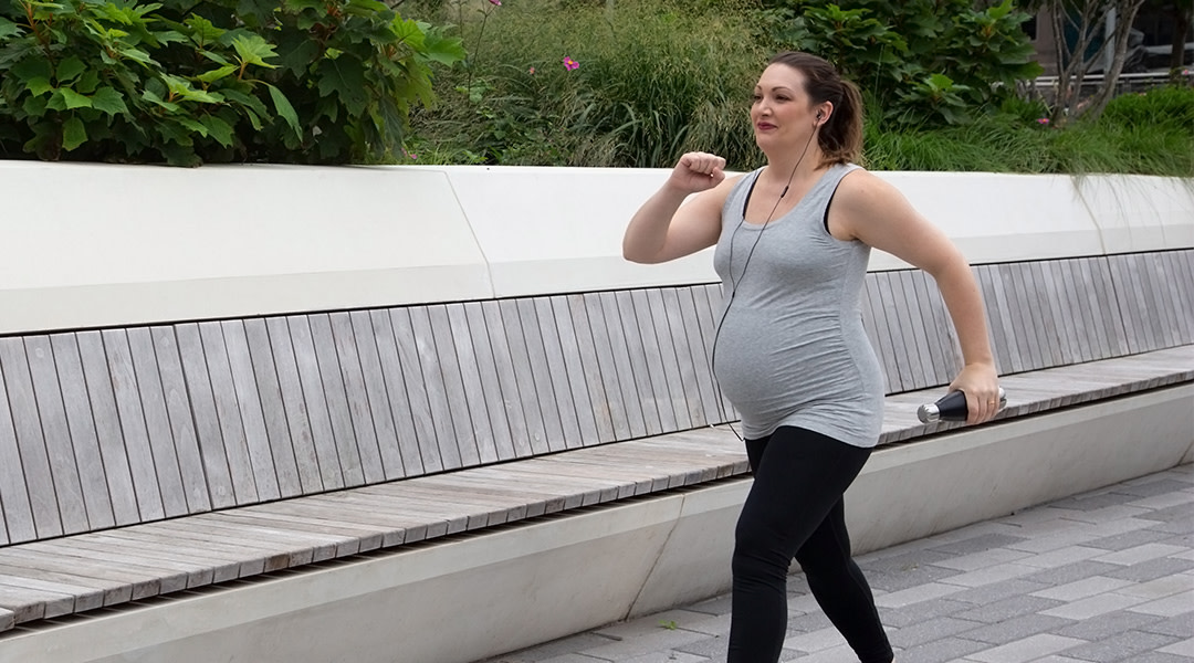 pregnant woman power walking in outdoor park