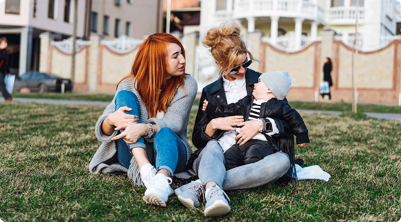 adult sisters with baby hanging out in the park
