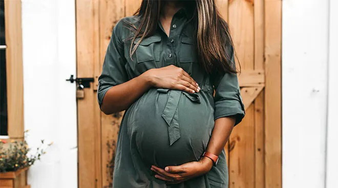 Pregnant woman with her hands on her belly. 
