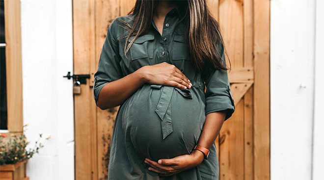 Pregnant woman with her hands on her belly. 