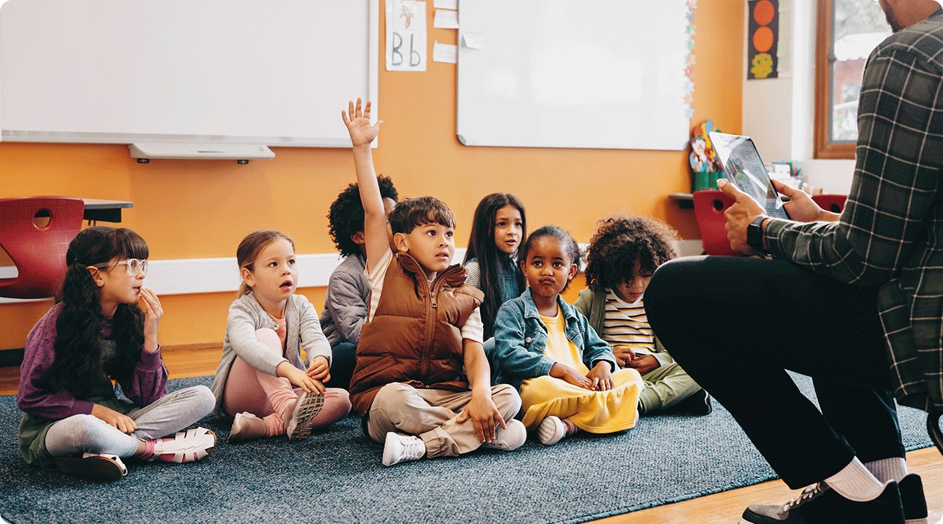 teacher sitting with young students